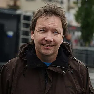 Mann med brunt hår og brun jakke